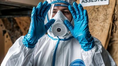 Person in protective gear for asbestos testing highlighting safety and precautions